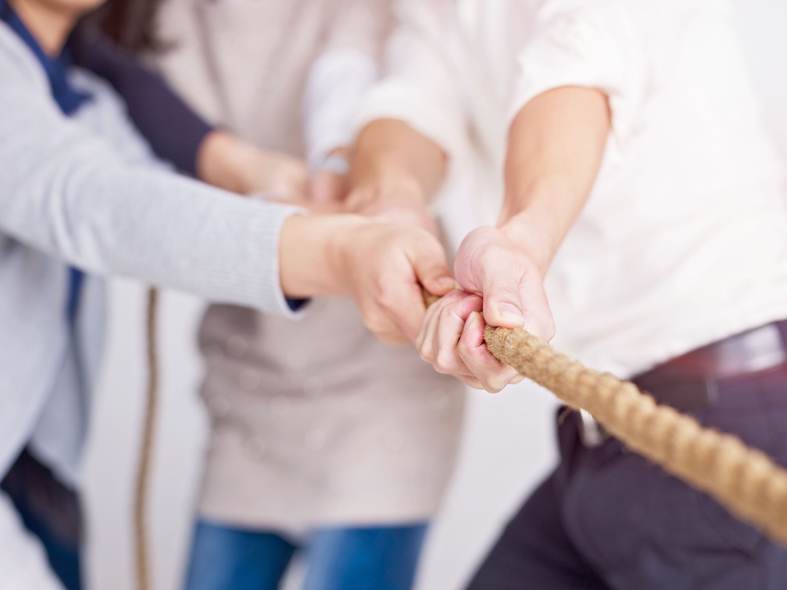 group of business people playing tug-of-war